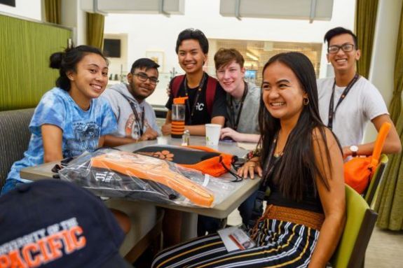 Pacific Student hanging out at a table.