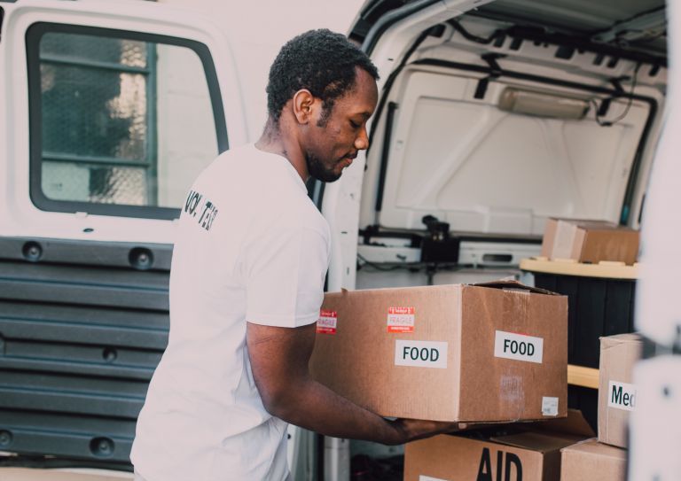 man loading food donations into vehicle