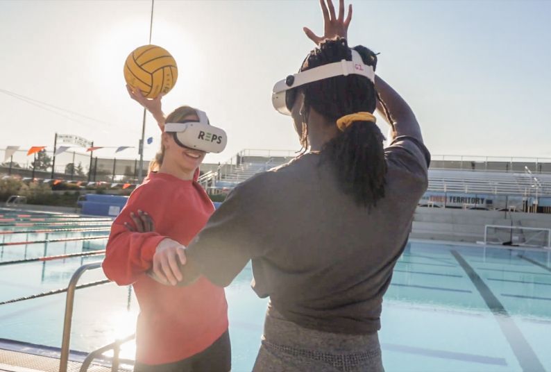 two water polo players demonstrate virtual reality equipment