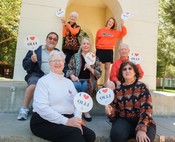 A group of OLLI members hold "I love OLLI" signs